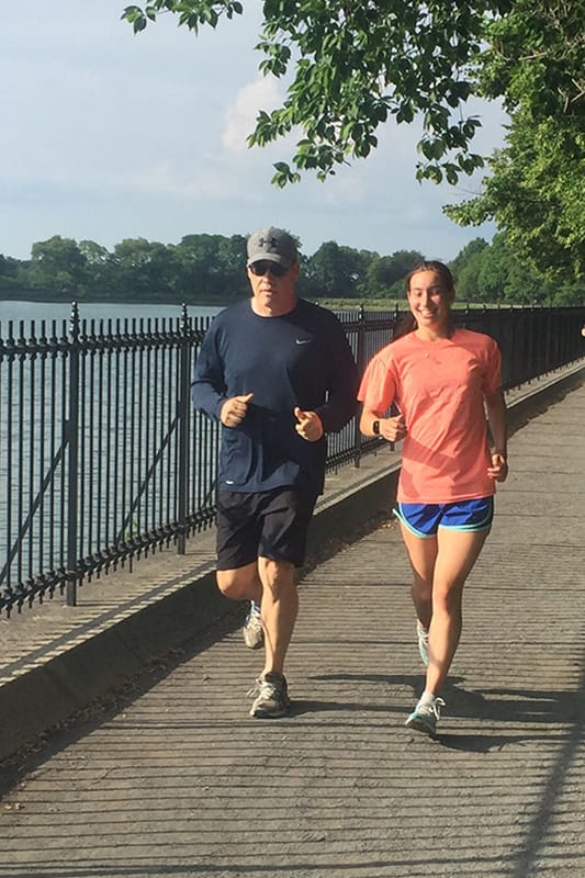 Photo of Greg Gaumer and his daughter running near a lake