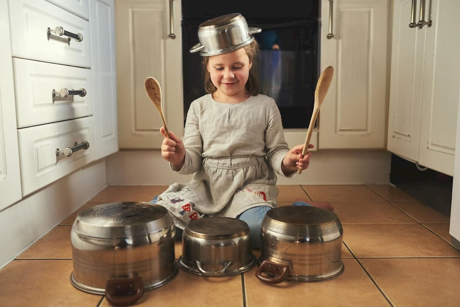 Child with ADHD banging on pots and pans with wooden spoons